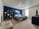 Spacious main bedroom with blue accent wall, bookshelf, and natural light from arched window at 5898 W Asbury Pl, Lakewood, CO 80227