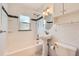 Cozy bathroom features white tiling, a tub/shower combo, pedestal sink and updated fixtures at 2565 S Gaylord St, Denver, CO 80210