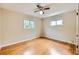 An empty bedroom boasts hardwood floors, neutral walls, a ceiling fan, and natural light from two windows at 2565 S Gaylord St, Denver, CO 80210