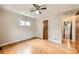 A bright bedroom features hardwood floors, a ceiling fan and view of a bathroom at 2565 S Gaylord St, Denver, CO 80210
