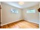 Bright bedroom featuring two windows, hardwood floors, and neutral paint at 2565 S Gaylord St, Denver, CO 80210
