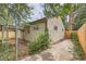 Exterior side view of the house with a fenced yard, patio, and mature landscaping at 2565 S Gaylord St, Denver, CO 80210