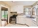 Charming kitchen featuring white cabinets, stainless steel appliances, and tile countertops at 2565 S Gaylord St, Denver, CO 80210