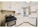 Bright kitchen with white cabinets, stainless steel range, and a double basin sink under a window at 2565 S Gaylord St, Denver, CO 80210