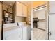Bright laundry area features washer, dryer, cabinetry, and access to kitchen with tile flooring at 2565 S Gaylord St, Denver, CO 80210