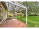 Covered brick patio featuring string lights and view of the spacious backyard with mature trees at 2565 S Gaylord St, Denver, CO 80210