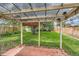Covered brick patio featuring string lights and view of the spacious backyard with mature trees at 2565 S Gaylord St, Denver, CO 80210