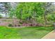 Landscaped backyard with tiered gardens, mature trees, and artificial turf at 8866 E Easter Ave, Centennial, CO 80112