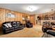 Spacious living room with bar, carpet, wood paneling, and an open view into the kitchen and dining area at 8866 E Easter Ave, Centennial, CO 80112
