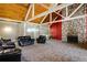 Open clubhouse featuring black leather sofas, stone fireplace, and wood beamed ceiling at 3035 Oneal Pkwy # 35T, Boulder, CO 80301