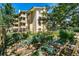 A lush community garden showing raised garden beds with various plants and a multi-story building in the background at 3035 Oneal Pkwy # 35T, Boulder, CO 80301