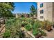 A vibrant community garden showing raised garden beds with lush plants and vegetables under a sunny sky at 3035 Oneal Pkwy # 35T, Boulder, CO 80301