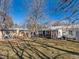 View of a back yard showing the detached garage, covered patio, and adjacent lawn at 3145 S Ash St, Denver, CO 80222