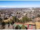 A neighborhood view featuring tennis courts with the city skyline and mountains in the background on a clear, sunny day at 3145 S Ash St, Denver, CO 80222