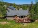 Aerial view of a log home with solar panels and beautiful decks in a lush setting at 32209 Blue Springs Dr, Evergreen, CO 80439