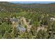 Beautiful aerial view of wooded property and mountain neighborhood with evergreen trees at 32209 Blue Springs Dr, Evergreen, CO 80439