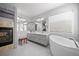 Bright bathroom featuring double vanity, fireplace, soaking tub, and large window with natural light at 32209 Blue Springs Dr, Evergreen, CO 80439