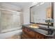 Bathroom featuring glass-enclosed shower, wood vanity, and decorative lighting at 32209 Blue Springs Dr, Evergreen, CO 80439
