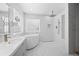 Bright bathroom featuring soaking tub, rainfall shower head, and double vanity at 32209 Blue Springs Dr, Evergreen, CO 80439