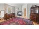 Cozy bedroom features a decorative fireplace, large window, and hardwood floors topped with an ornate rug at 32209 Blue Springs Dr, Evergreen, CO 80439