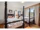 Cozy bedroom with two four-poster beds, hardwood floors, and a window with a view of the outdoors at 32209 Blue Springs Dr, Evergreen, CO 80439