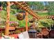 Charming outdoor deck with pergola, hanging floral baskets, comfortable seating, and serene wooded views at 32209 Blue Springs Dr, Evergreen, CO 80439