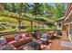 Inviting outdoor deck with a pergola, comfortable seating and a view of the surrounding greenery at 32209 Blue Springs Dr, Evergreen, CO 80439
