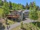 Charming multi-level home with stone chimney, large deck, and solar panels surrounded by lush trees at 32209 Blue Springs Dr, Evergreen, CO 80439