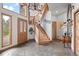 Grand foyer with flagstone flooring, wood staircase, and beautiful chandelier creates an inviting entrance at 32209 Blue Springs Dr, Evergreen, CO 80439
