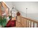 Well-lit hallway with wooden floors, a large painting, and an elegant chandelier hanging from the high ceiling at 32209 Blue Springs Dr, Evergreen, CO 80439