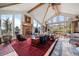Elegant living room boasts vaulted ceilings, a stone fireplace, and expansive windows offering scenic views at 32209 Blue Springs Dr, Evergreen, CO 80439