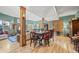 Open-concept living and dining area with hardwood floors and wooden columns at 32209 Blue Springs Dr, Evergreen, CO 80439