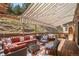 Relaxing outdoor patio with a retractable awning, comfortable seating, and a serene mountain backdrop at 32209 Blue Springs Dr, Evergreen, CO 80439