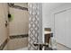 Well lit bathroom features tiled shower stall, shower curtain and brown vanity at 12143 Dahlia Dr, Thornton, CO 80241