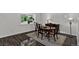 Dining room features an oval table, dark wood flooring, and natural light from the window at 12143 Dahlia Dr, Thornton, CO 80241
