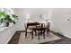 Dining room features an oval table, dark wood flooring, an area rug, and a large plant at 12143 Dahlia Dr, Thornton, CO 80241