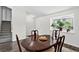 Warm dining room featuring an oval table, dark wood flooring, and natural light from the window at 12143 Dahlia Dr, Thornton, CO 80241