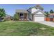 Charming two-story home with a well-maintained lawn, stone accents, and a welcoming front porch at 12143 Dahlia Dr, Thornton, CO 80241
