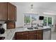 Bright kitchen featuring stainless steel appliances, marble countertops, and backyard view at 12143 Dahlia Dr, Thornton, CO 80241