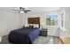 Bright main bedroom with decorative headboard, ceiling fan, and view from the window at 12143 Dahlia Dr, Thornton, CO 80241