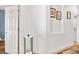 Bright hallway with white walls, wood floors, and decorative wall art at 8944 Fox Dr, Denver, CO 80260