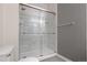 Modern shower with marble-look surround and sliding glass doors at 8944 Fox Dr, Denver, CO 80260