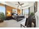 Tranquil bedroom featuring wood accent wall, ceiling fan, and large windows at 16034 Columbine St, Thornton, CO 80602