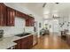 Modern kitchen featuring wood cabinets, sleek appliances, and views into living area at 3768 S Acoma St, Englewood, CO 80110