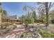 Backyard with a gravel pathway, raised garden beds, trees, and a privacy fence at 6922 W Walden Pl, Littleton, CO 80128