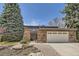 Charming home featuring stone accents, a two-car garage, a well-maintained lawn and beautiful landscaping at 6922 W Walden Pl, Littleton, CO 80128