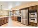 Well-lit kitchen with stainless steel appliances and wood cabinets at 6922 W Walden Pl, Littleton, CO 80128
