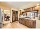Charming kitchen with wood cabinets, cooktop, and view into other living areas at 6922 W Walden Pl, Littleton, CO 80128