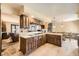 Bright kitchen with wood cabinets, cooktop, and open view into living and dining areas at 6922 W Walden Pl, Littleton, CO 80128