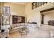 Cozy living room showcasing a stone fireplace, large windows and custom bookshelf at 6922 W Walden Pl, Littleton, CO 80128